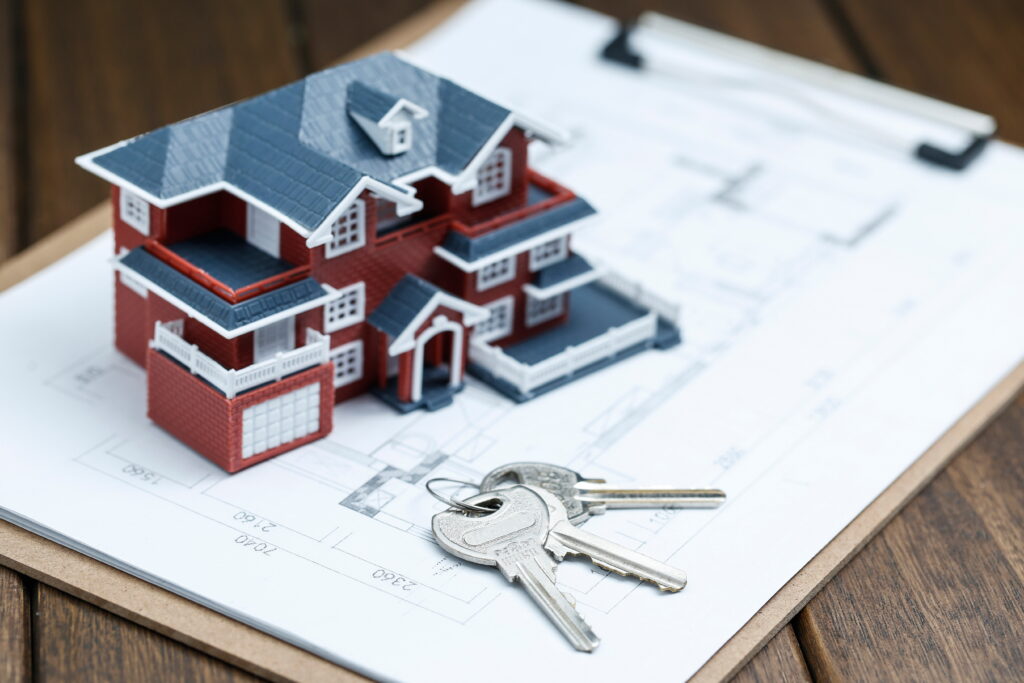 villa house model, key and drawing on retro desktop (real estate sale concept)